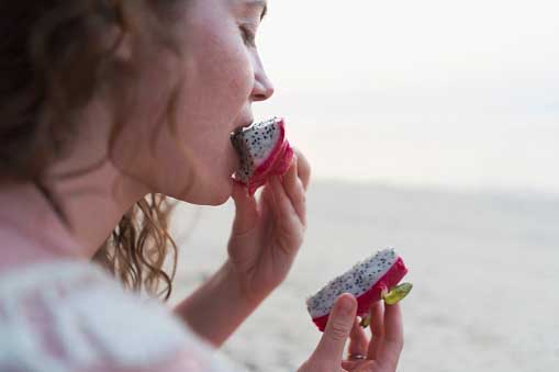 young woman eating dragon fruit